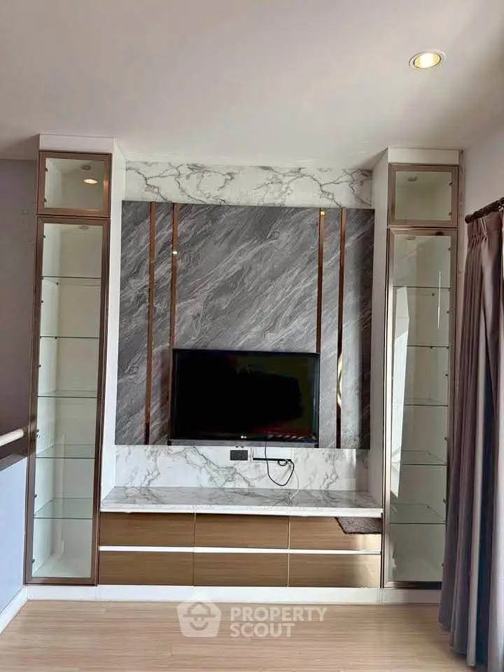 Luxurious living room with elegant marble TV wall and modern shelving units.