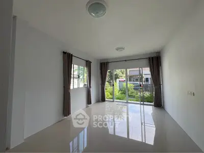 Spacious unfurnished living room with large windows and garden view.