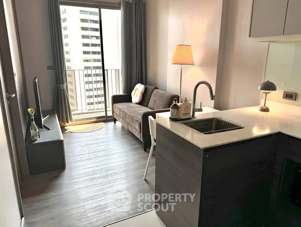 Modern living room with open kitchen and balcony view in urban apartment