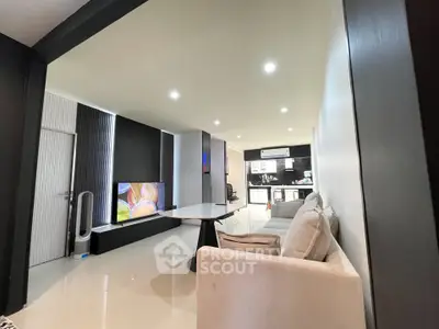 Modern living room with sleek design and open layout, featuring comfortable seating and stylish decor.