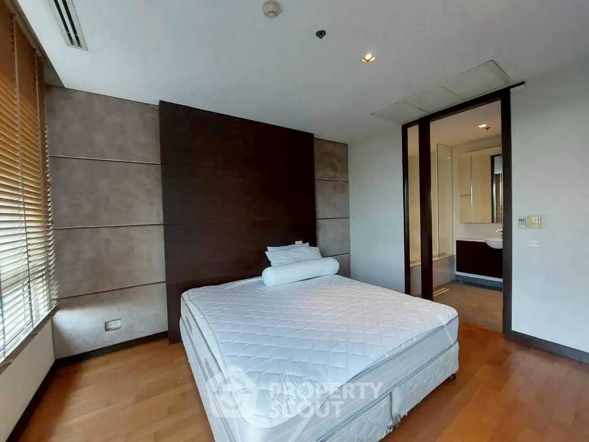 Spacious bedroom with modern design and ensuite bathroom in luxury apartment.