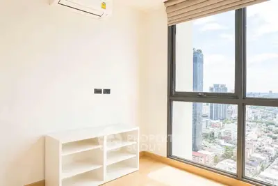 Bright corner unit with large windows offering stunning city views, featuring built-in shelving and air conditioning.