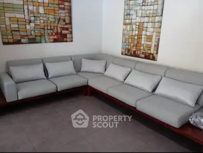 Modern living room with stylish sectional sofa and abstract wall art