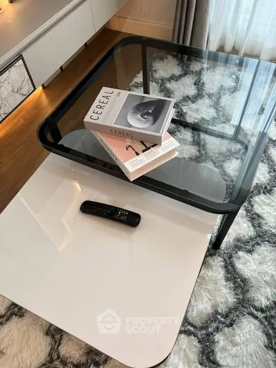 Stylish modern living room with glass coffee table and chic decor books