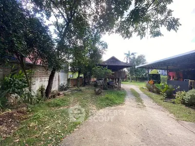 Charming rural property with traditional wooden house and lush greenery, perfect for serene living.