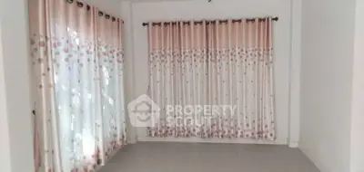 Spacious room with elegant polka dot curtains and ample natural light.