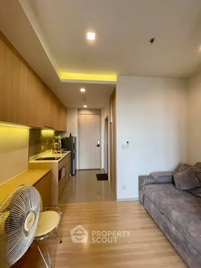 Modern living room with cozy sofa and stylish kitchen in open layout apartment.