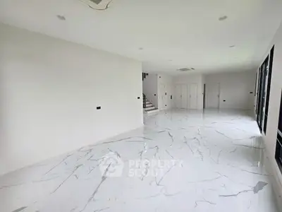 Spacious modern interior with marble flooring and ample natural light, perfect for luxury living.