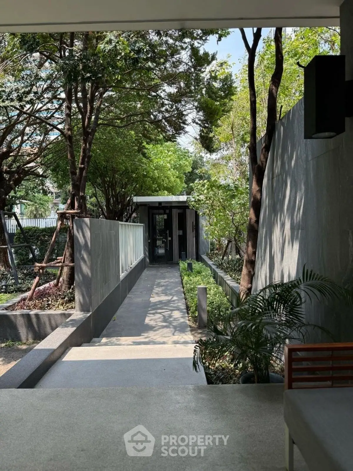 Modern garden entrance with sleek design and lush greenery