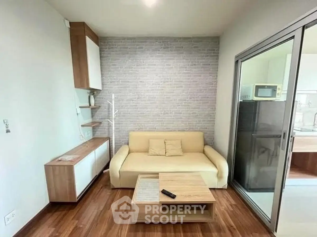 Modern living room with stylish furniture and sliding glass door to kitchen area.