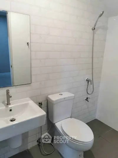 Modern bathroom with sleek fixtures and white subway tile walls, featuring a shower and toilet.