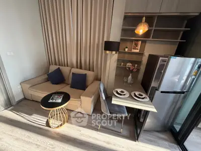 Modern living room with cozy sofa, stylish dining area, and sleek kitchen appliances.