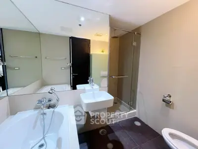 Modern bathroom with glass shower and bathtub in luxury apartment