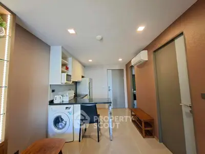 Modern kitchen with washing machine and sleek appliances in open layout