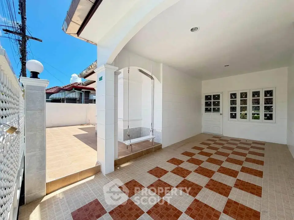 Spacious tiled outdoor area with covered section and bright open space, perfect for versatile use.