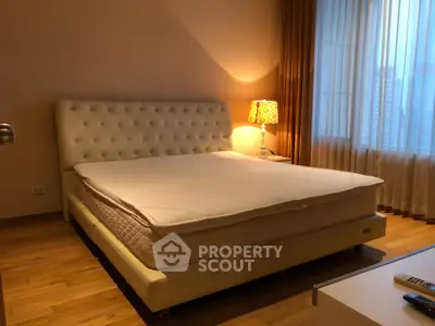 Cozy bedroom with elegant bed and warm lighting, perfect for relaxation.
