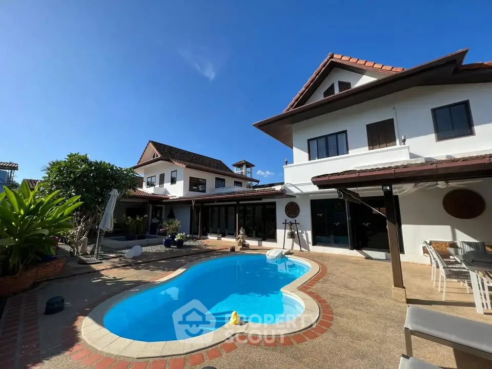 Stunning villa with private pool and spacious outdoor area under clear blue skies.