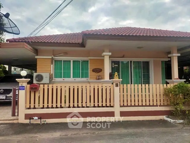 Charming single-story house with red-tiled roof and fenced yard in a serene neighborhood.