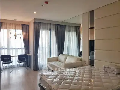 Modern bedroom with large windows and stylish furniture in a high-rise apartment.