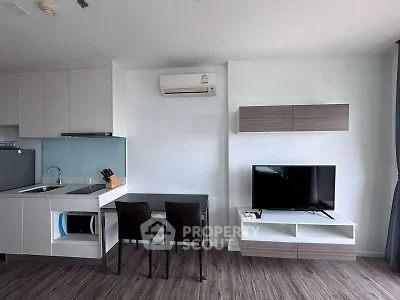 Modern living room with sleek kitchen and stylish furniture in a contemporary apartment.