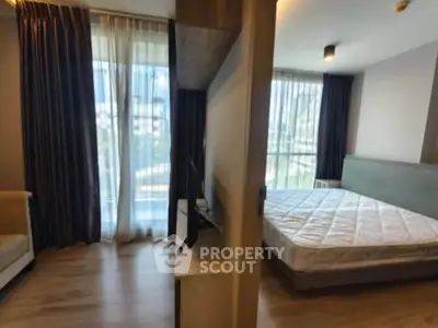 Modern apartment with spacious bedroom and living area, featuring large windows and natural light.