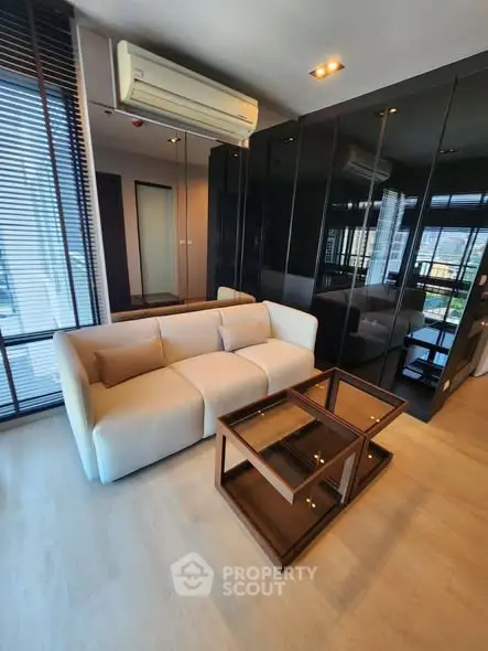 Modern living room with sleek design, featuring a comfortable sofa and stylish glass coffee table.