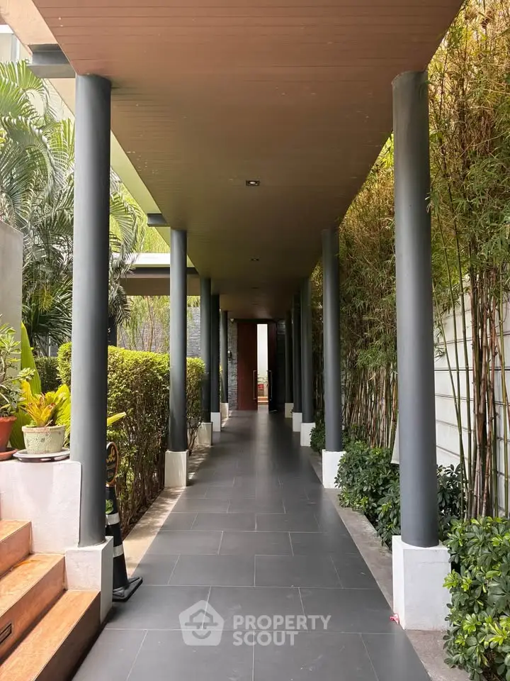 Elegant entrance with modern design and lush greenery, perfect for luxury real estate appeal.