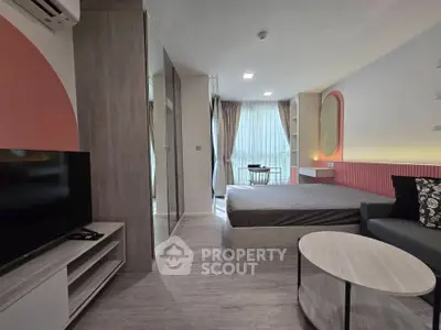 Modern studio apartment with stylish decor, featuring a cozy bed, sleek TV unit, and ample natural light.