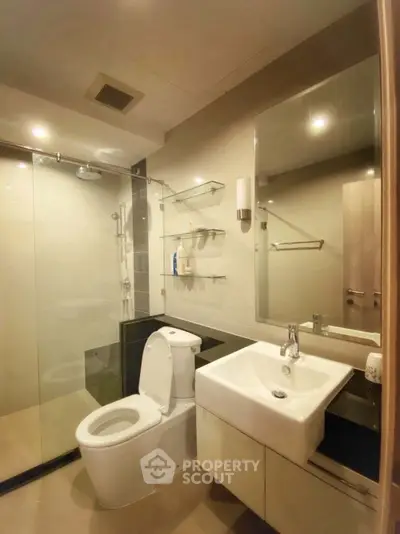 Modern bathroom with glass shower and sleek fixtures in a contemporary apartment.