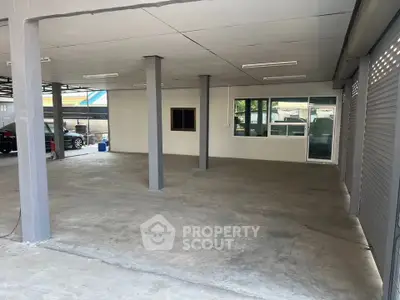 Spacious open garage area with concrete flooring and multiple support columns, ideal for parking or storage.