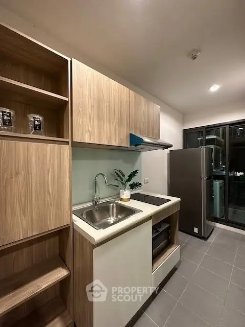 Modern kitchen with sleek cabinetry and stainless steel appliances in a contemporary apartment.