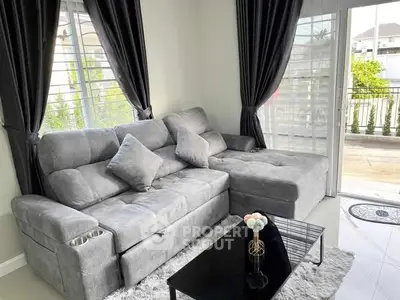 Stylish living room with plush gray sofa and elegant decor, offering a cozy and inviting atmosphere.