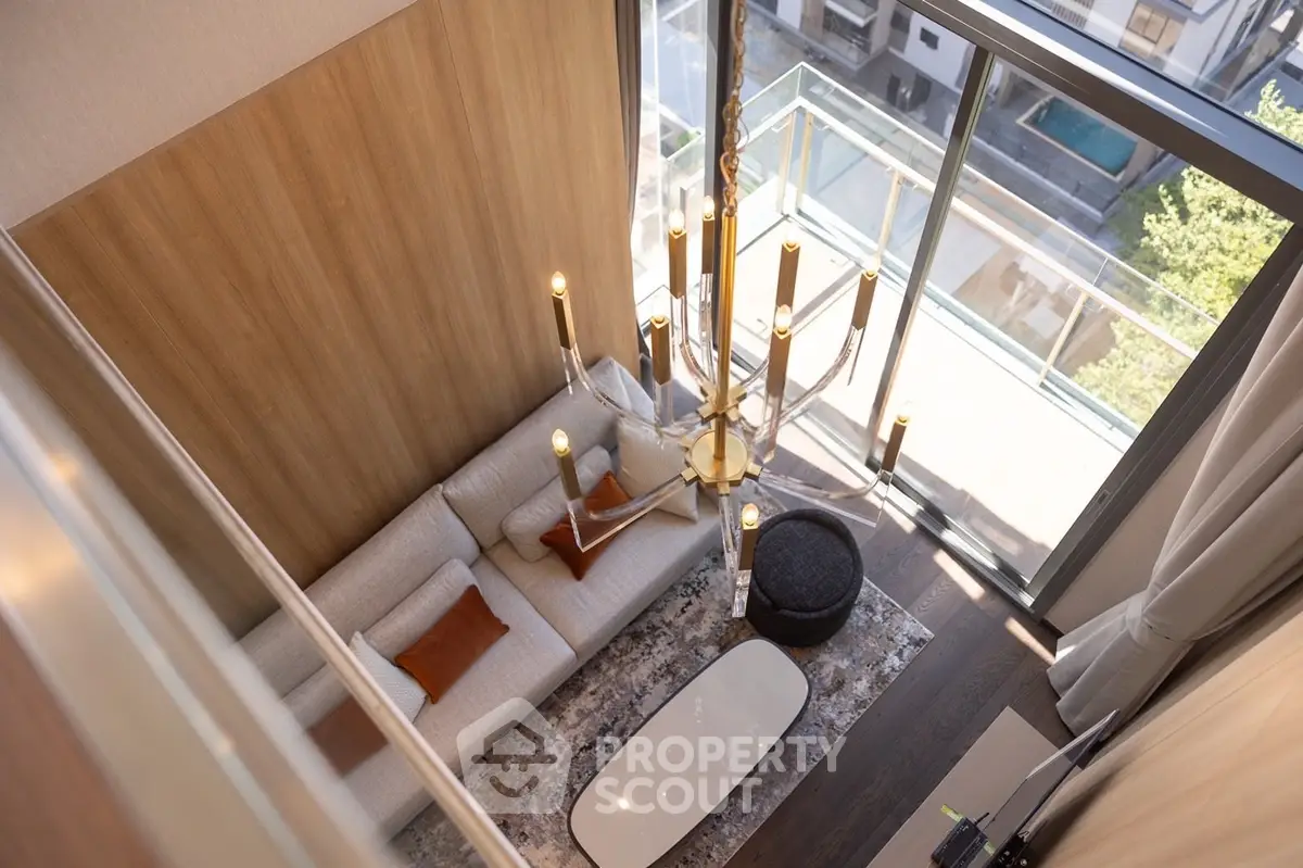 Luxurious modern living room with high ceiling and elegant chandelier in a stylish apartment.