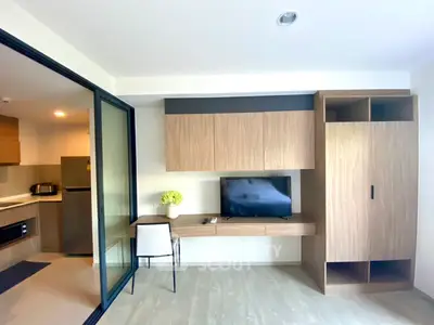 Modern living room with sleek wooden furniture and open kitchen layout