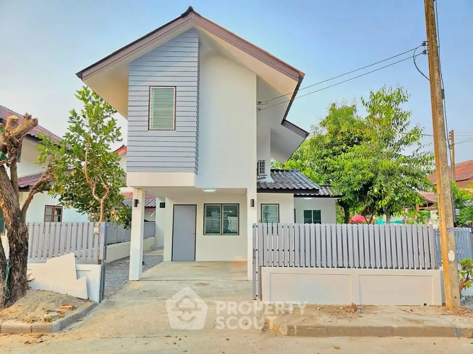 Charming modern two-story house with fenced yard and driveway in a serene neighborhood.