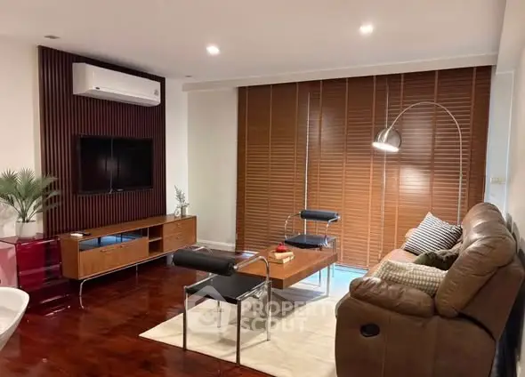 Stylish living room with modern furniture and wooden blinds, perfect for relaxation.