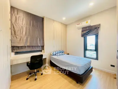 Modern bedroom with single bed, desk, and window view in a stylish apartment.