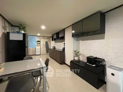 Modern kitchen with sleek cabinets and dining area in contemporary apartment