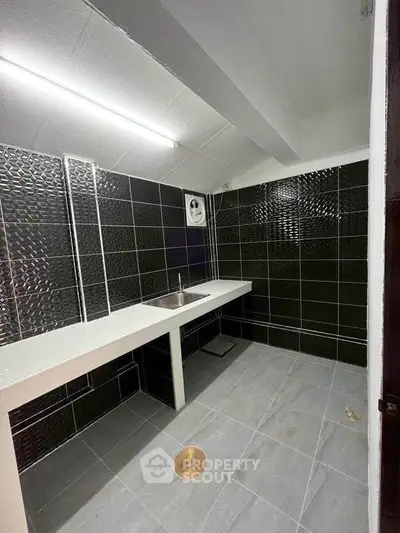 Modern kitchen with sleek black tiles and minimalist design