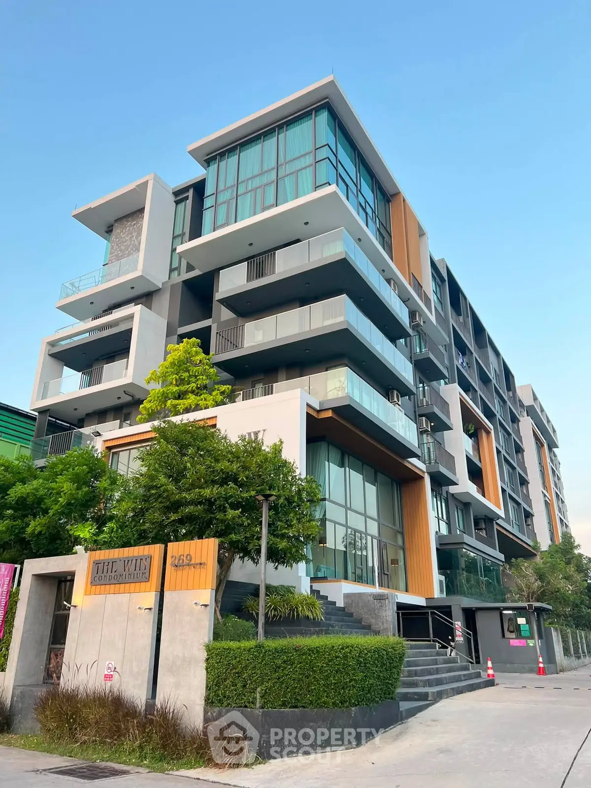 Modern multi-story apartment building with sleek design and large windows in urban setting.