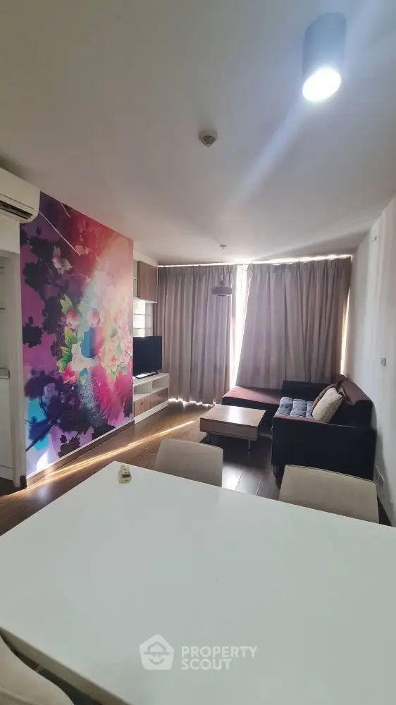 Modern living room with vibrant wall art and cozy seating area