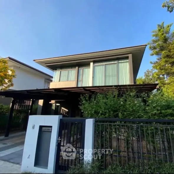 Modern two-story house with sleek design and lush greenery