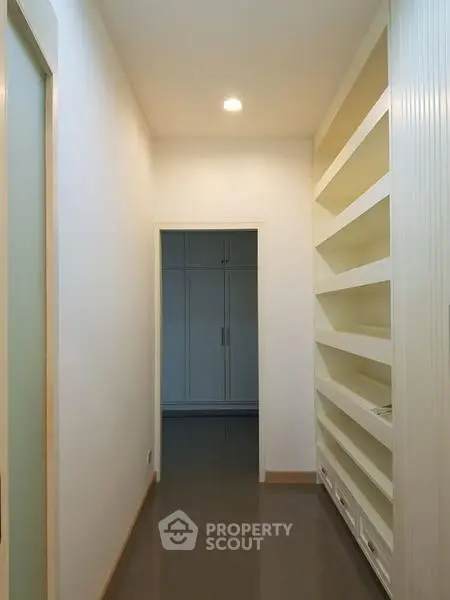 Spacious hallway with built-in shelves and modern lighting