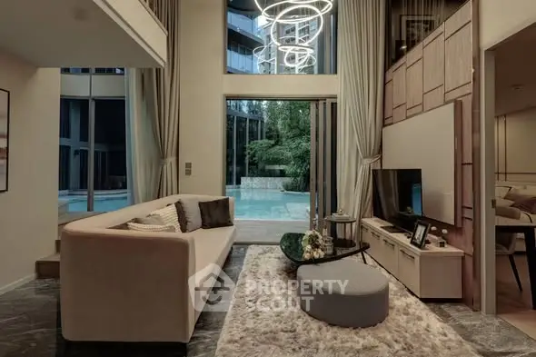 Luxurious living room with modern decor and pool view, featuring elegant lighting and plush furnishings.