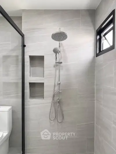 Modern bathroom with sleek shower and neutral tiles, perfect for a contemporary home.