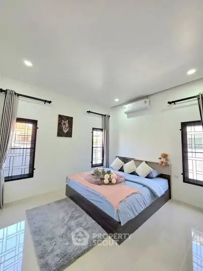 Modern bedroom with stylish decor, featuring a cozy bed, elegant curtains, and air conditioning.