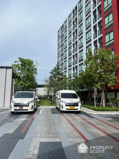 Modern apartment building with parking area and greenery