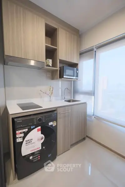 Modern compact kitchen with built-in appliances and city view