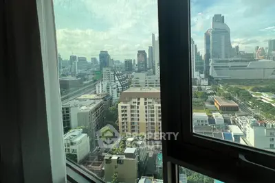 Stunning cityscape view from high-rise apartment window, showcasing urban skyline and modern architecture.