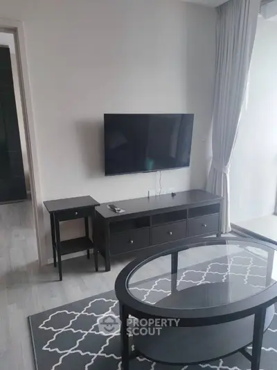 Elegant living room with modern furnishings, featuring a large flat-screen TV, stylish coffee table, and chic decor, perfect for urban living.